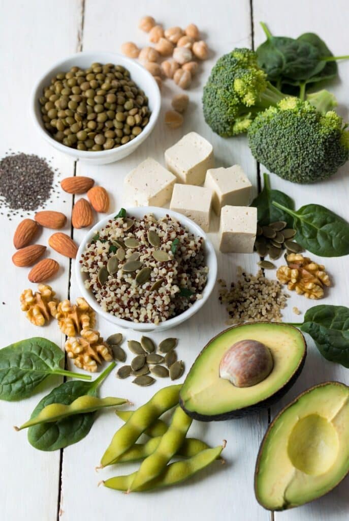 fruits, graines et légumes biologiques sur une table en bois blanc ayant tous un indice glycémique bas