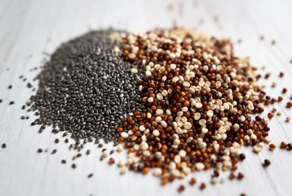 pseudo-céréales, graines de chia et de quinoa en vrac sur une table en bois